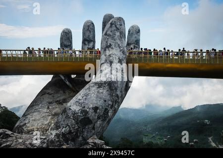 La vista del famoso Ponte d'Oro e' sollevata da due mani giganti nel resort turistico sulla collina di Ba Na a da Nang, Vietnam. Foto di viaggio. Maggio 22,2024 Foto Stock