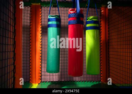 Borse da pugno appese per i bambini in una casa giochi al coperto. Foto Stock