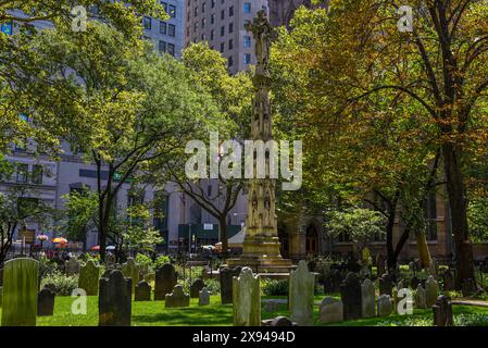 L'Astor Cross Monument tra le lapidi del Trinity Churchyard a Lower Manhattan, New York City Foto Stock