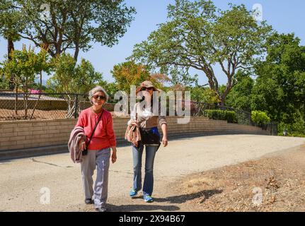 Donna anziana che cammina con figlia in una giornata di sole. California. Foto Stock