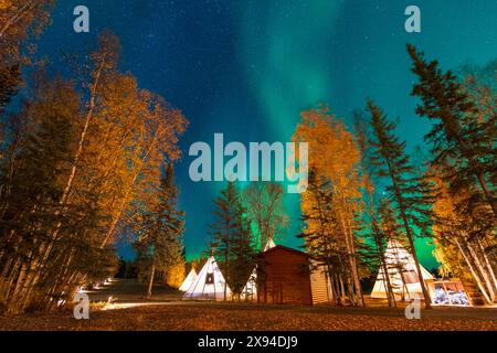 Incredibile aurora boreale che balla sopra la luce di tipi o Tepees all'Aurora Village di Yellowknife, territori del Nord-Ovest, Canada. Foto Stock