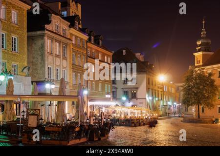 Piazza del Castello (Plac Zamkowy) di notte con ristoranti all'aperto intorno a edifici bassi tradizionali, la città Vecchia, Varsavia, Polonia, Europa Foto Stock