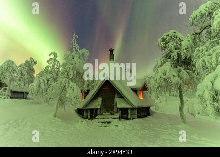 Aurora boreale (Aurora Boreale) sopra un rifugio nel bosco della Lapponia finlandese, il Parco nazionale Pallas-Yllastunturi, Muonio, Lapponia, Finlandia Foto Stock