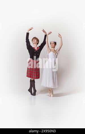 Ballerina in abito bianco e corona floreale e la sua compagna in tradizionale kilt scozzese e giacca in perfetta posa con lo studio bianco Foto Stock