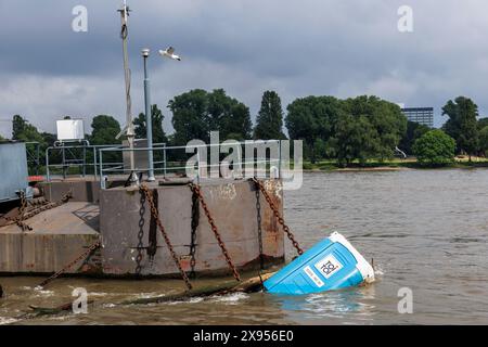 Una toilette mobile galleggia su un molo nel Reno, Colonia, Germania. 15.02.2024 eine Dixi toilette treibt an einem Schiffsanleger im Rhein, Koeln, Deutsc Foto Stock