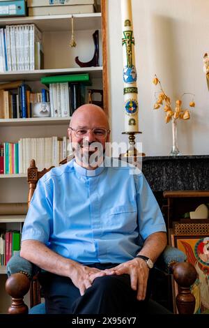 Portait sacerdote cattolico Tilburg, Paesi Bassi. Living Room Ritratto di un sacerdote cattolico di 56 anni seduto sulla sua sedia da lettura, mentalmente e spiritualmente preparandosi per la sua nuova commissione datagli dal suo Vescovo. MRYES Tilburg Parochie Binnenstad Nootd-Brabant Nederland Copyright: XGuidoxKoppesxPhotox Foto Stock