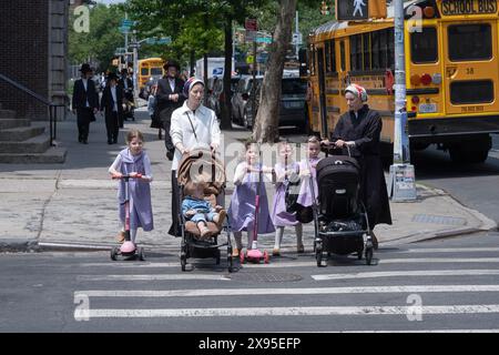 2 madri ebraiche chassidiche e diversi bambini aspettano che una luce cambi prima di attraversare. A Brooklyn, New York. Foto Stock