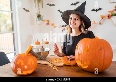 la moglie della casa ottiene un calcio fuori di intagliare la zucca Per Halloween Foto Stock