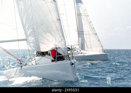 Due yacht con vele fluttuanti si sfidano in una regata sull'oceano scintillante Foto Stock