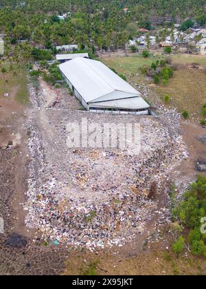 Veduta aerea di una grande discarica di rifiuti su una piccola isola tropicale Foto Stock