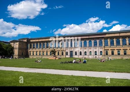 Alte Pinakothek (Pinakothek vecchia), famoso museo d'arte della città di Monaco, Germania. Persone che si rilassano sull'erba di fronte all'edificio. Foto Stock