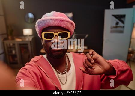 POV di Black man che scatta foto di selfie o registra video per i social media indossando uno spazio di copia rosa alla moda Foto Stock