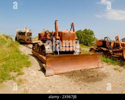 I vecchi bulldozer erano usati per trainare le barche in acqua e tornare con la barca su rimorchio nelle dune sulla costa di Wairarapa. Foto Stock