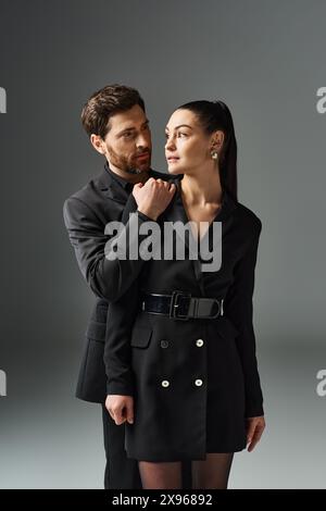 Un uomo e una donna, entrambi vestiti elegantemente, stanno fianco a fianco. Foto Stock