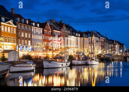 Edifici colorati e barche a alberi alti sul lungomare di Nyhavn di notte, Nyhavn Canal, Nyhavn, Copenhagen, Danimarca, Europa Foto Stock