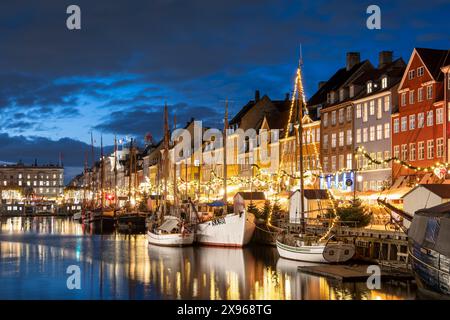 Edifici colorati e barche a alberi alti sul lungomare di Nyhavn di notte, Nyhavn Canal, Nyhavn, Copenhagen, Danimarca, Europa Foto Stock