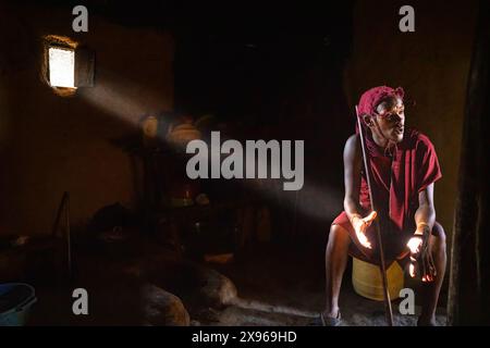 Un uomo tribale dei Maasi Mara dall'interno della sua capanna di fango, Kenya, Africa orientale, Africa Foto Stock