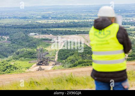 Sprengung Eines Absetzers im Tagebau Hambach, 29.5.2024 Sprengmeister Michael Schneider beobachtet die Szenerie - RWE Power Hat AM 29.5.2024 im Tagebau Hambach einen so genannten Absetzer gesprengt. MIT ungefähr 27 Kilo Sprengstoff, verteilt auf 300 Sprengladungen, wurde das riesige Gerät zerkleinert. Zuerst sollte die Maschine, Baujahr 1961, noch ein Braunkohlebagger werden, später wurde sie aber doch ein Absetzer. DAS macht sie zu einem Exokten im Tagebau: Baggerfahrwerk und Absetzer-Aufbau. DAS Gesamtgewicht beträgt 3818 Tonnen. Der Absetzer War Hoch da 47 metri, lang da 148 metri e 42 Jahre im Foto Stock