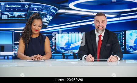 TV Live News Program: Due diversi presentatori professionisti che riportano gli eventi. Televisione via cavo, Newsroom Studio: White male, Black Female Anchors Talk. Concetto di rete di trasmissione mockup Foto Stock