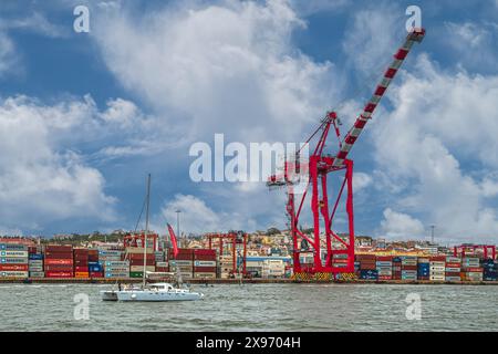 Gru rosse e navi container nel porto di Lisbona (Porto de Lisboa), il terzo porto più grande del Portogallo. Foto Stock