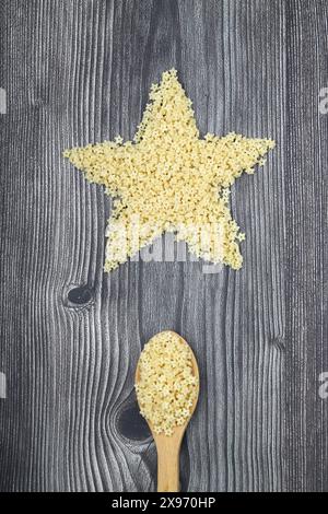 Vista dall'alto della pasta alle stelline organiche crude in una ciotola. Posizione piana, sovratesta, dall'alto. Le stelle dei Macaroni. Spaghetti a forma di stella. Foto Stock