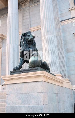 Madrid, Spagna - 15 aprile 2024. Uno dei due leoni di bronzo fuori dall'edificio del Congresso dei deputati spagnolo. Foto Stock