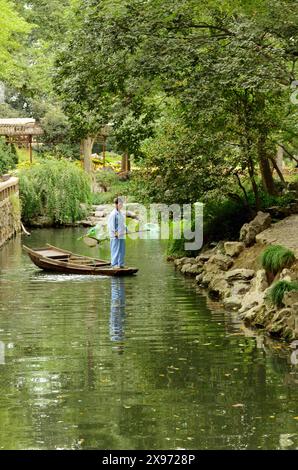 Barcaiolo e riflesso sul lago nel giardino dell'amministratore dell'umile giardino dell'amministratore, Suzhou, Jiangsu, Cina Foto Stock