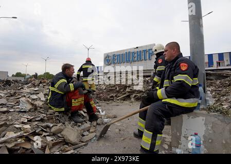 Charkiv, Ucraina, 29 maggio 2024. I vigili del fuoco e i soccorritori si prendono una pausa dalla ricerca dei detriti del negozio epicentro K nella zona settentrionale della città dopo che le bombe guidate russe UMPB D30-SN hanno colpito il negozio sabato. Un uomo di 40 anni è morto oggi in ospedale dopo aver subito gravi ustioni durante l'attacco, portando il bilancio delle vittime a 19. G P Essex/Alamy Live News Foto Stock