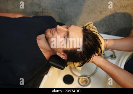 Uomo che si fa lavare i capelli nel barbiere Foto Stock