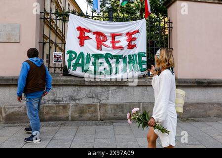 28 maggio 2024, Cracovia, Malopolskie, Polonia: Passanti su una strada Grodzka simbolo guardare lo striscione "Palestina libera" mentre gli studenti dell'Università Jagiellonia tengono uno sciopero occupazionale nel cortile del Collegium Broscianum per una settimana a sostegno della Palestina. Gli studenti hanno organizzato uno sciopero pacifico contro l'attacco israeliano alla Palestina. Gli studenti polacchi hanno protestato contro quello che chiamano genocidio, in quanto più di 35 mila palestinesi sono stati uccisi in questo conflitto di 7 mesi. Israele ha attaccato la Striscia di Gaza dopo che Hamas si è infiltrato e ha ucciso più di 11 centinaia di persone in Israele il 7 ottobre 2023. (Immagine di credito: © Dom Foto Stock