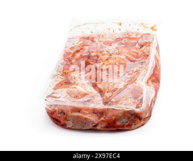 Carne di pollo cruda marinata in imballaggi sottovuoto su sfondo bianco Foto Stock