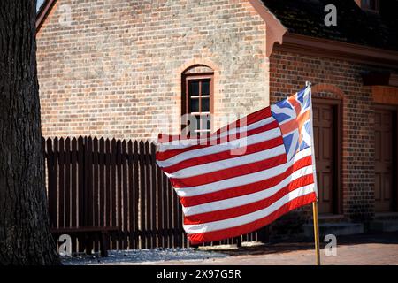 Una bandiera della Grand Union soffia nel vento sulla strada a Colonial Williamsburg, Virginia. Foto Stock