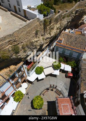 Vista aerea di un villaggio spagnolo con stradine strette e mura di pietra, circondato da edifici e alberi in estate, vista aerea, abitazioni nelle grotte Foto Stock