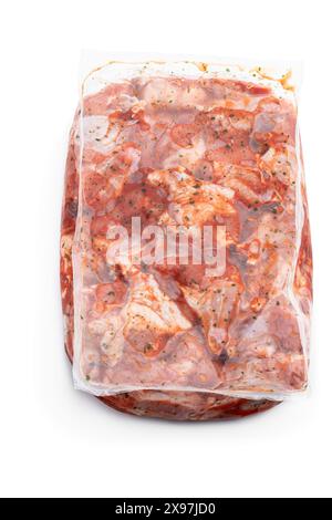 Carne di pollo cruda marinata in imballaggi sottovuoto su sfondo bianco Foto Stock
