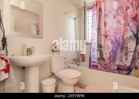 bagno con tenda doccia rosa e wc in porcellana bianca Foto Stock