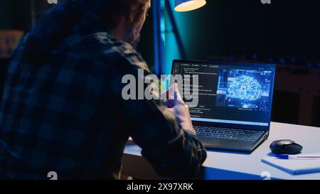 Informatico che aggiorna l'algoritmo di apprendimento automatico dell'intelligenza artificiale, scrivendo script di codice binario. Lo specialista IT del telelavoro negli uffici di appartamenti utilizza la programmazione per aggiornare l'IA, la telecamera A. Foto Stock