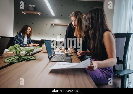 Giovani professionisti impegnati in una discussione collaborativa in uno spazio di lavoro moderno Foto Stock