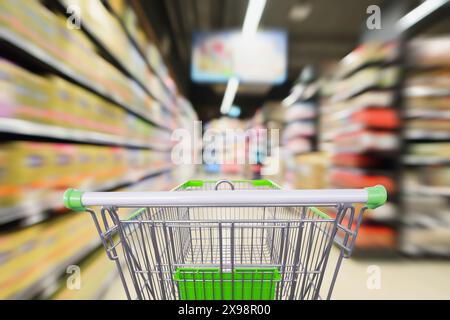 gli scaffali del supermercato sono affiancati da un carrello in movimento con sfocature interne Foto Stock