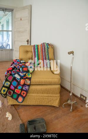 Divano solitario avvolto in coperte in una casa abbandonata Foto Stock