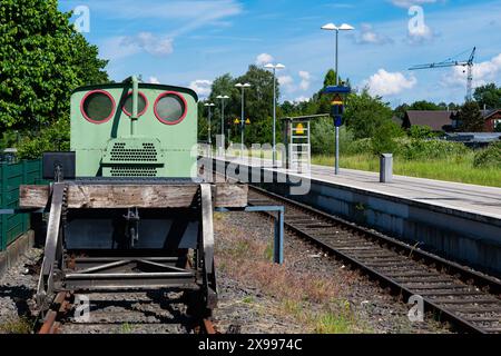 Una piattaforma ferroviaria vuota per passeggeri e una vecchia piccola locomotiva in piedi su binari senza uscita. Foto Stock