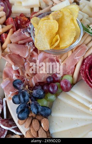 Delizioso assortimento di tapas salate su un banco di salumi per un'esperienza culinaria condivisa, con affettati come il prosciutto serrano e i chorizos Foto Stock