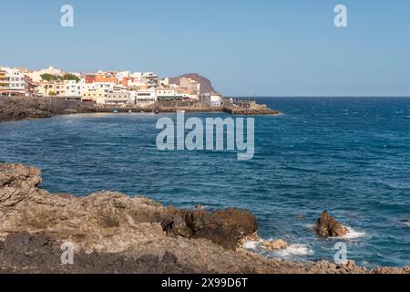 Viste dell'aspra costa vulcanica e dell'Oceano Atlantico blu profondo e dell'affascinante villaggio di pescatori di Los Abrigos con i suoi edifici colorati, Tenerife Foto Stock