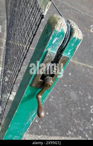 vecchio manico per avvolgere la rete da tennis sulla superficie del campo duro, devon, inghilterra Foto Stock
