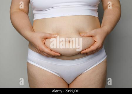 Donna che tiene lo stomaco da vicino Foto Stock