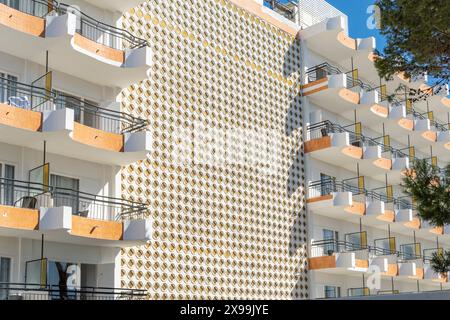 Cala d'Or, Spagna; 04 maggio 2024: Facciata con balconi di un vecchio edificio di appartamenti turistici nella città di Cala d'Or in una mattinata di sole Foto Stock