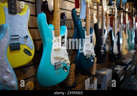 Una chitarra elettrica Fender American Vintage II turchese appesa ad altre chitarre elettriche in vendita al Gak Music Emprorium di Brighton, East Sussex, U Foto Stock