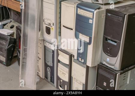 Una discarica di vecchi computer rotti in attesa di essere rottamati e riciclati sul pavimento. Foto di alta qualità Foto Stock