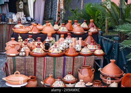 Mostra in un mercato del Marocco con alcune delle ceramiche di argilla. Tajine arancione pentole e vasi da cucina tradizionali con decorazioni ornamentali Foto Stock