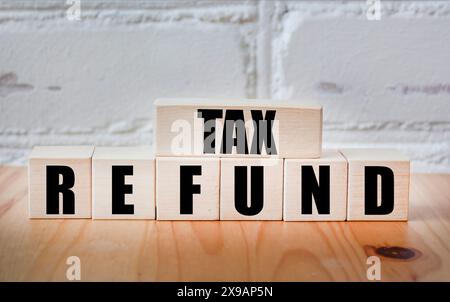 Rimborso delle imposte - pagamento al contribuente quando paga più tasse di quelle che deve sui blocchi di legno Foto Stock