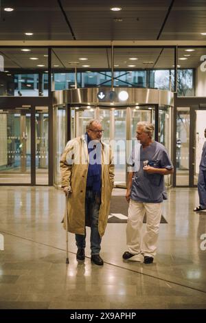 Medico che parla con paziente anziano nella hall dell'ospedale Foto Stock